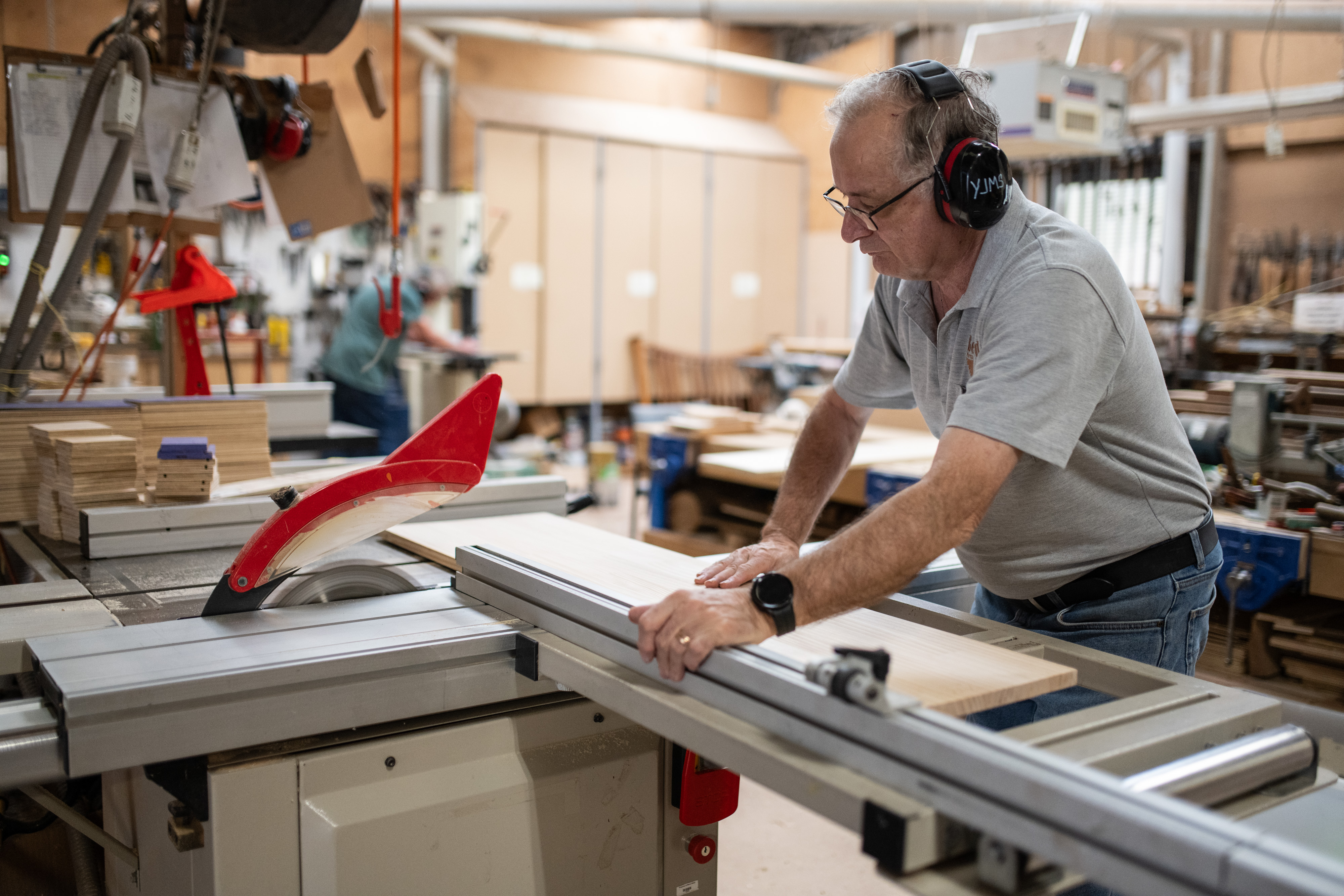 Man working in a workshop he is wearing earmuffs