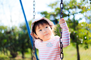 young child on a swing in a park