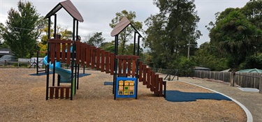 Back view of climbing tower with slides and game boards