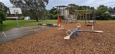 Play equipment with climbing elements and basketball court