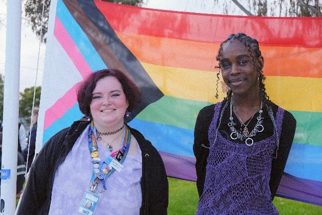 Two young people celebrating the pride flag