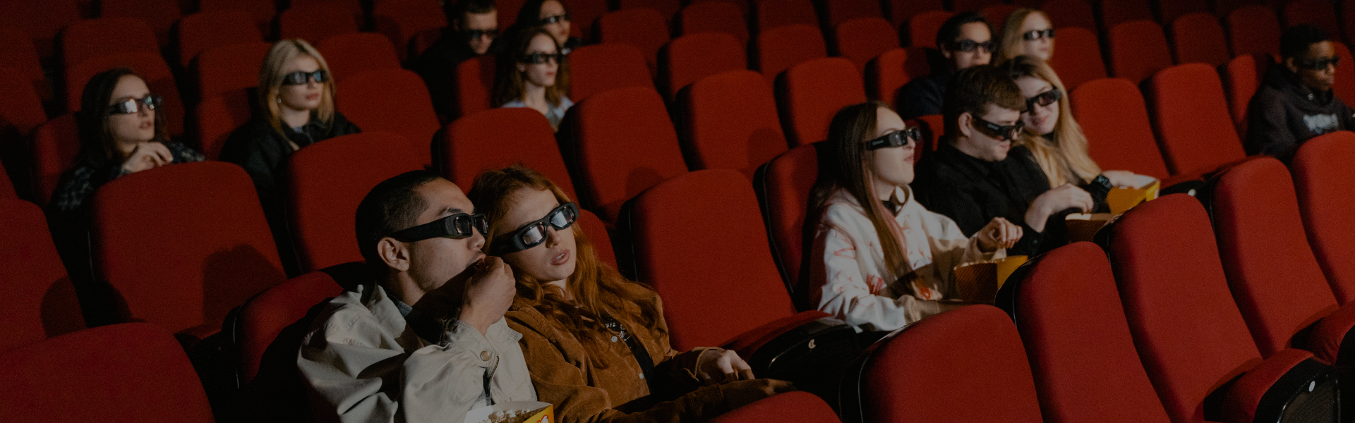 People watching movie with 3D glasses at a cinema.