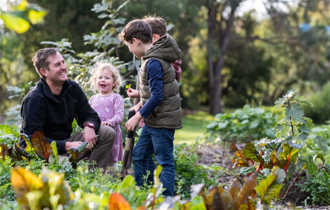 Dad with his three children enjoying some time in the garden together