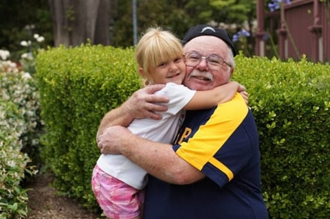 child-hugging-her-grandfather-outdoors