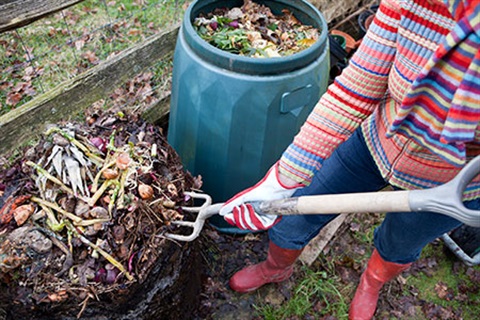 Person turning over compost with a garden fork